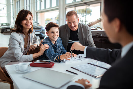 Family at Car Dealership Receiving Keys to New Vehicle