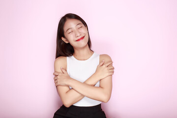 Portrait of a beautiful young woman in a light pink background, half body photo of nice positive lady crossed arms posing empty space ad isolated.