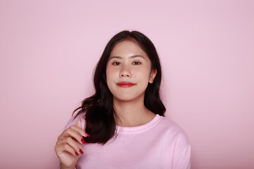 Portrait of a beautiful young woman in a light pink background, happy and smile, posting in stand position, half body photo of nice positive lady, Portrait of a friendly young woman smiling happily.