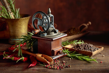 Vintage pepper mill with various peppers and spices.