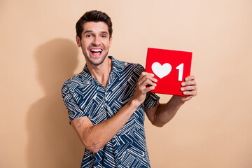 Photo of young surprised guy holding red cube click button subscription his new x social media account isolated on beige color background