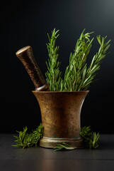Old brass mortar with fresh rosemary branches.