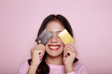 Asian woman holding a credit card in her hand Holding a debit card in hand A beautiful young woman...