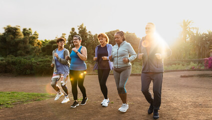 Group of diverse senior friends jogging together at park