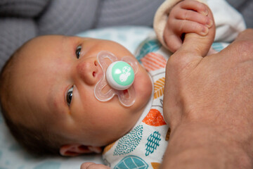 Neugeborener Junge im Bett mit Kuscheltier - obrazy, fototapety, plakaty