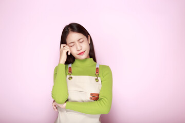 Fototapeta premium Asian woman making an angry expression, Portrait of a young woman in a light pink background.