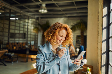 Young business woman using smartphone on coffee break in modern workspace