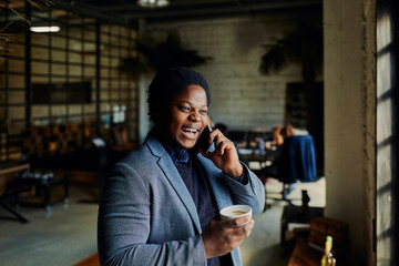 Young businessman having phone call on coffee break in office