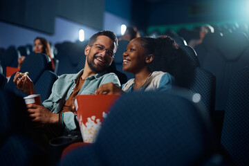 Cheerful couple has fun during movie projection in cinema. - obrazy, fototapety, plakaty