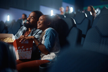 Happy couple enjoying in movie projection in cinema.