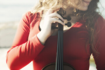 romantic scene of a woman playing the violin passionately in front of the sea