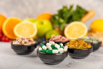 Obraz na płótnie Canvas Vitamins and supplements. Variety of vitamin tablets in a jar on a texture background.Multivitamins with fresh and healthy fruits.Food supplements. Flat lay. Space for text.Copy space