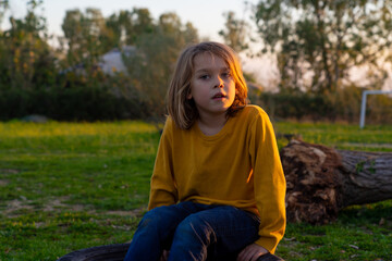 Portrait of 7 year old boy sitting in the field
