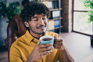 Photo portrait of handsome young guy wear yellow shirt smell aroma coffee mug work pause workplace stylish room interior home office design