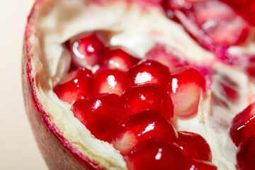 Pomegranate and pomegranate leaves on a beige background.