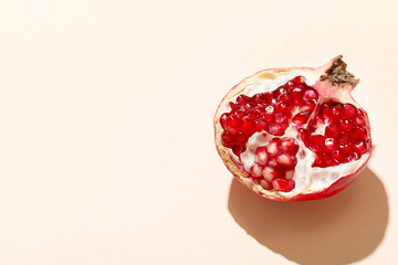 Pomegranate and pomegranate leaves on a beige background.