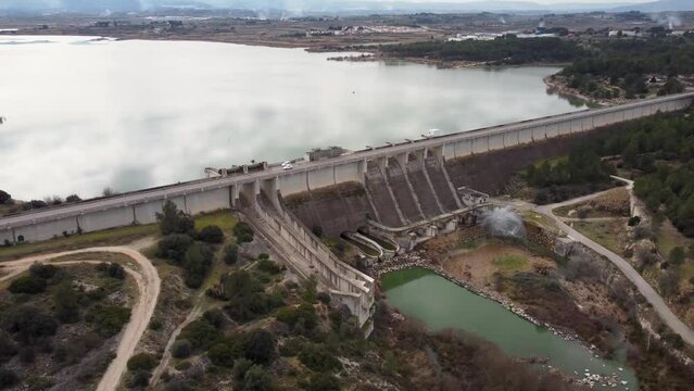 Panning drone video of the Bell&uacute;s gravity dam for irrigation and water containment, in the province of Valencia, Spain with a Relief valve working at full capacity
