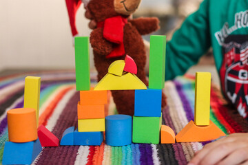 Toys colorful geometric shapes on educational games on bright mat made of fabric threads and child...