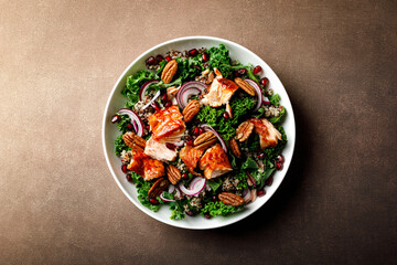 Salmon superfood salad with grilled fish, kale, quinoa, pecan nuts, red onion and pomegranate. Top...