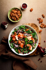 Salmon superfood salad with grilled fish, kale, quinoa, pecan nuts, red onion and pomegranate. Top...