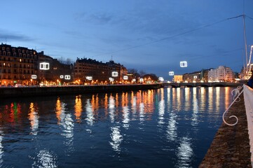 Obraz premium At Christmas, the lights that decorate the city reflect in the water of the river, creating a beautiful night vision. 