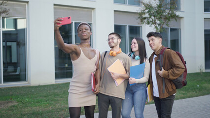 Positive multiethnic students taking selfie on street