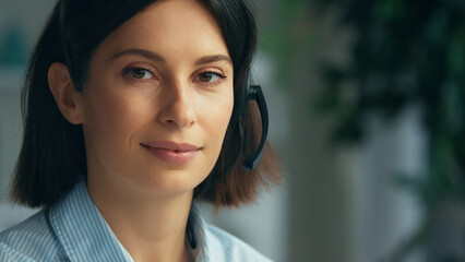 Young woman working in a call center. Happy smiling call center operator answering phone calls...