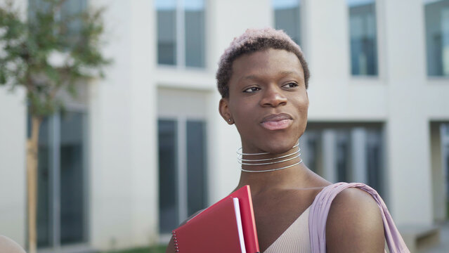 Content queer black man with folder on street