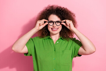 Photo portrait of lovely young lady touch specs cheerful toothy smile wear trendy green garment isolated on pink color background