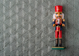 Traditional wooden toy for Christmas, Nutcracker on a soft blanket. Horizontal, free space for notes.