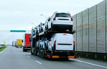 Car carrier trailer truck with brand new commercial vehicles for sale. New car delivery. Car...