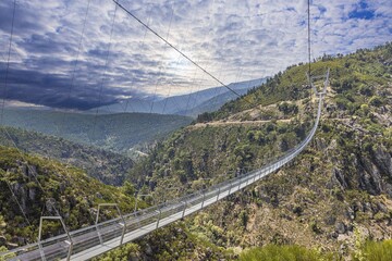 View along an impressive suspension bridge over a deep valley during the day