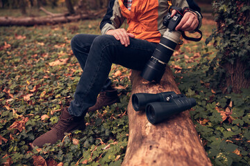 Fototapeta na wymiar Man using binoculars and camera for bird and animal watching in nature.