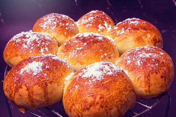 baked buns on an iron grid on a background of black marble