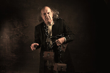 Ghost of Jacob Marley, Scrooge ex-business partner, chained with a padlock, carrying treasure chests and keys