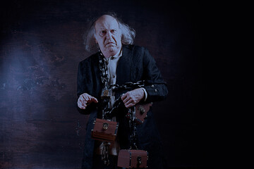 Ghost of Jacob Marley, Scrooge ex-business partner, chained with a padlock, carrying treasure chests and keys