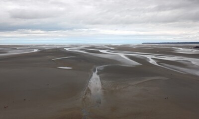 low tide from Mont Saint Michel Abbey in northern France and very small people walking
