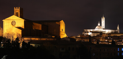 night panorama of the city of Siena with the cathedral and the church of San Domenico