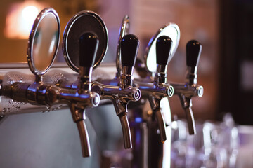 Beer taps in a cozy bar, an atmosphere of beer craftsmanship and pleasure. Aesthetics of beer...