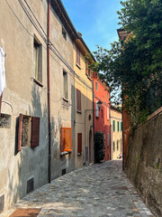 A narrow stone street winds its way through a vibrant canvas of colorful houses, each facade telling a unique story, creating a picturesque tapestry of life and joy.