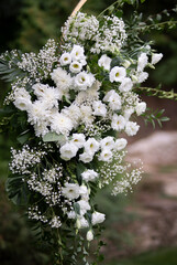 Wedding ceremony. Very beautiful and stylish wedding arch, decorated with various fresh flowers, standing in the garden.