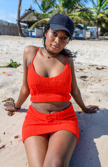 A young african lady seated on the beach sand enjoying the breeze