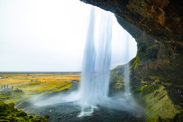 view from behind the waterfall; Seljalandfoss on the ring road, Iceland - obrazy, fototapety, plakaty