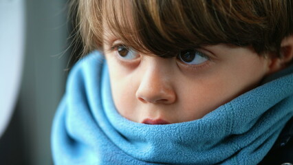 Fototapeta premium Close-up of a contemplative young caucasian boy, ensconced in a scarf, reflecting a depth of introspection, encapsulating a profound meditative state