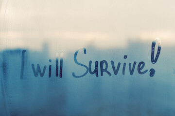 Hand drawn message I will survive on foggy glass on blue window