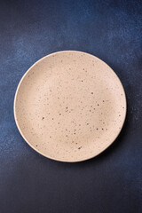 Round empty colored ceramic plate on concrete texture background