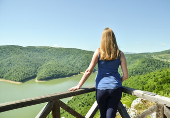 Young woman looking at the scenic views of mountains and lake