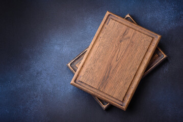 Empty rectangular wooden cutting board on dark concrete background