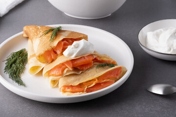 Pancakes with salmon, sour cream and greenstuff. Thin, not sweet blinchiki stuffed with red fish. Feast of Maslenitsa
