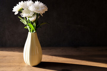 グレーの壁背景の花瓶に活けた白菊